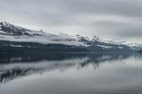 Clouds in layers on the snow capped mountains along the Inside passage, Alaska Stock Photos