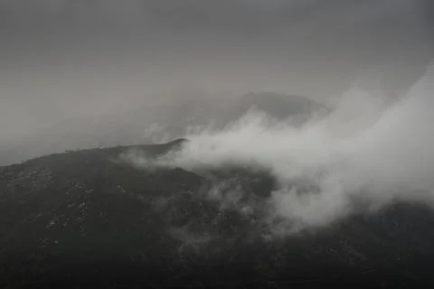 Clouds lifting up from the mountains Stock Photos