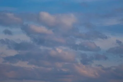 Clouds in the light of the setting sun, evening light on the clouds in the sk Stock Photos