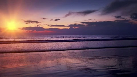 Clouds lit by setting sun on background. Ocean beach in twilight Stock Footage 73124591