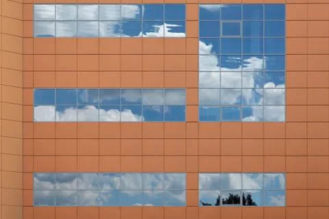Clouds lit by the setting sun reflecting in a modern office buil Stock Photos