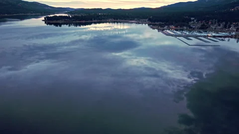 Clouds mirrored across still lake surface creating dramatic sky reflection Stockbeeldmateriaal 328899080