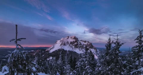 Clouds motion fast over rocky peak in frozen winter alps mountains forest at Stock Footage 235369770