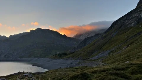 Clouds on a mountain peak lit by rising sunlight Stock Footage 95301352