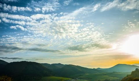 Clouds, mountains, sun Stock Photos