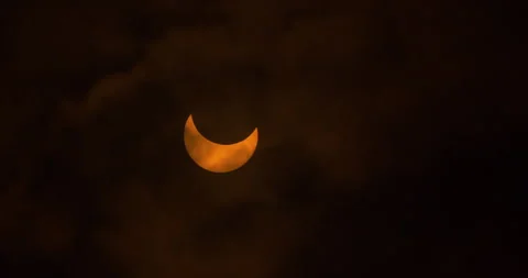 Clouds move across a partial solar eclipse, October 14th, 2023. Stock Footage 253372329