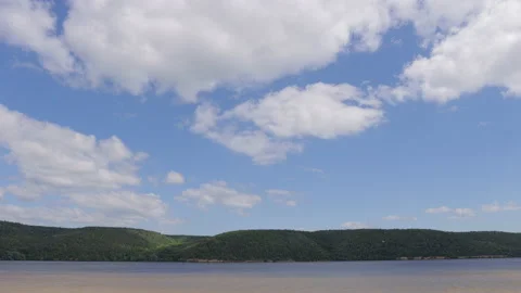 Clouds move across the sky on a sunny day over mountains and lake, timelapse 스톡 동영상 201675861