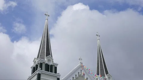 Clouds move across the sky in a timelapse view above a Catholic church tower Stock Footage 323810034