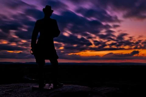 Clouds move behind a statue in a long exposure taken after sunset from little Stock-Fotos