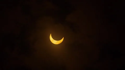 Clouds move in front of the sun during a partial solar eclipse, October Stock Footage 253372656