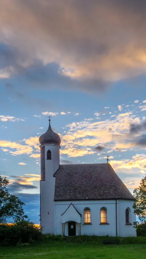 Clouds move over the Kreuzberg Chapel near Wessobrunn in the evening Stock Footage 277868286