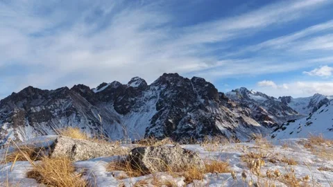 Clouds move over the tops of snow-capped rocks Stock Footage 144977035