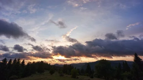 The clouds move quickly over the forest landscape at sunset 動画素材 171380173
