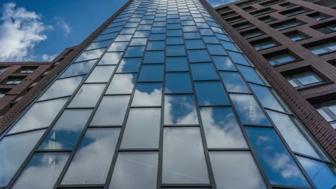 Clouds move quickly, reflected in the glass windows of a skyscraper Stock Footage 119487253