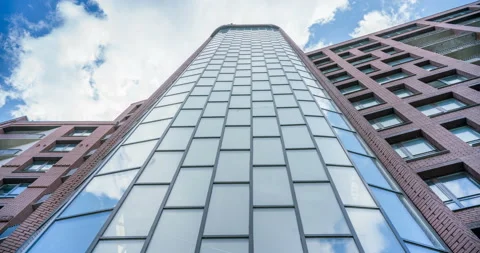 Clouds move quickly, reflected in the glass windows of a skyscraper Stock Footage 119552024