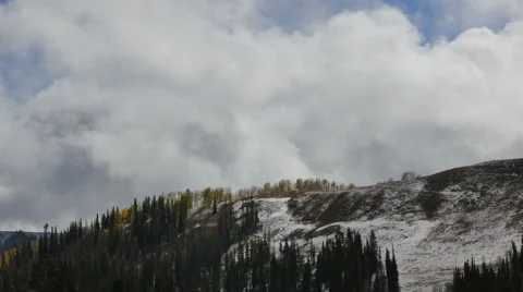 Clouds move rapidly over snowy mountain aspen trees pines Stock Footage 68544497