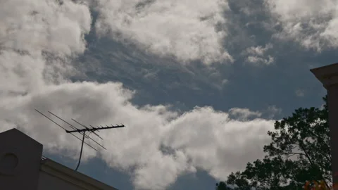 Clouds to move in unusual opposite directions above roofline of suburban houses. Stock Footage 252059376