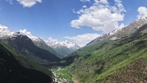 Clouds moving above mountain valley with village in timelapse Vídeo Stock 318868789