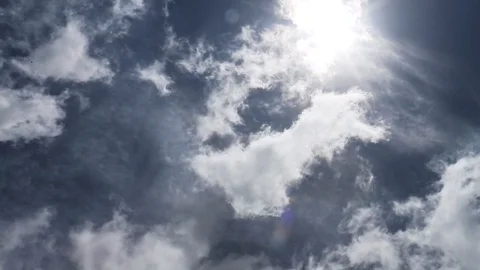 Clouds moving across clear skies with a bright sun 020519 Stockbeeldmateriaal 102883804