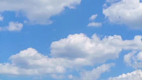 Clouds moving across the sky in a clear blue setting Stock Footage 340142994
