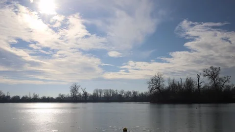Clouds moving across the sky over a frozen lake on a cold December morning Stock Footage 100521160