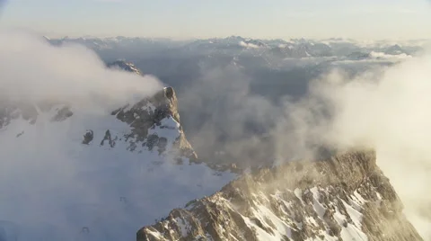 Clouds moving along snowy mountain peaks during summer Stock Footage 58630612