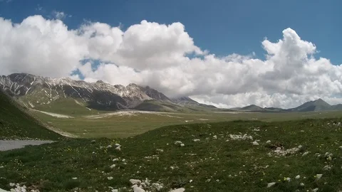 Clouds moving on alpine plateau with mountains around Stock Footage 89765706