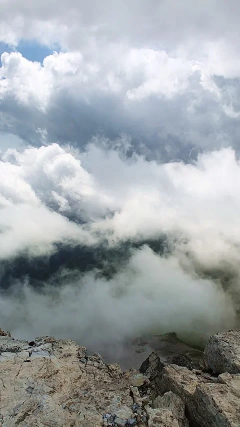 Clouds moving around rocky alpine peaks and ridges in a slow-motion manner Stock Footage 248058265