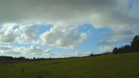 Clouds moving fast over a green field with blue sky TIMELAPSE Vídeos de archivo 143347374