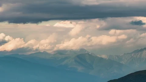 Clouds moving over alpine mountains in sunny summer evening Time lapse Stock Footage 108742356