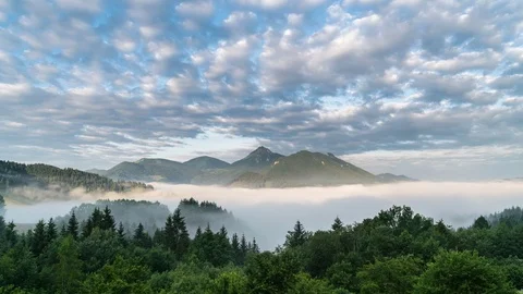 Clouds moving over blue sky in magic mountains, in foggy morning time lapse Stock Footage 80375574