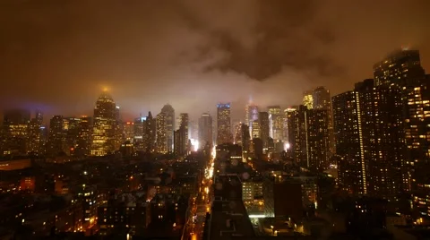 Clouds moving over city skyline at night sky. urban building lights background Stock Footage
