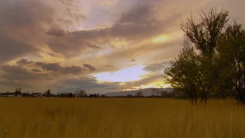 Clouds Moving over a Field at Sunset Video stock 73900220
