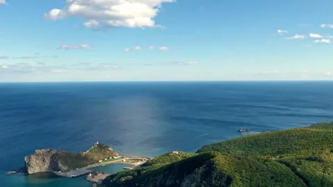 Clouds moving over green coastline in timelapse Stock Footage 318870356