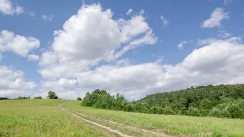 Clouds moving over green field and country road time lapse Stock Footage 69181956