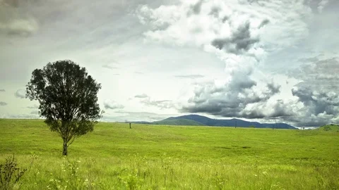 Clouds moving over green landscape Stock Footage 76100366