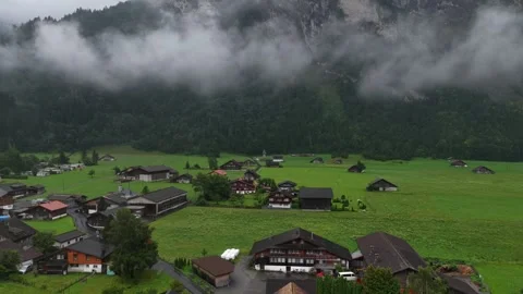 Clouds moving over green valley and traditional houses in switzerland Stock Footage 317317461