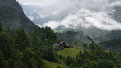 Clouds moving over green valley with isolated house in the austrian alps Stock Footage 317318546