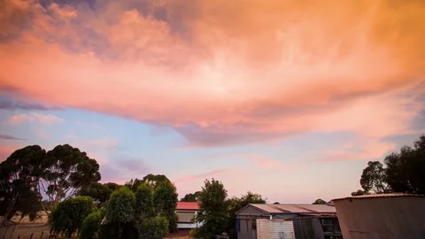 Clouds moving over houses at dusk Stock Footage 76101506