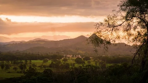 Clouds moving over the landscape during sunset Stock Footage 76101364