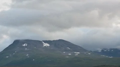 Clouds moving over majestic mountain peak with snow patches timelapse Stock Footage 47347902