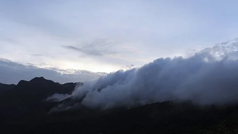 Clouds moving over the mountains ranges during sunset Stock Footage 81231511