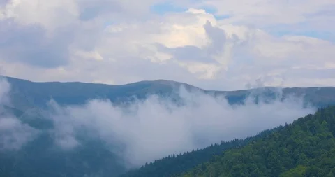 Clouds moving over mountains in summer day Stock Footage 93794854