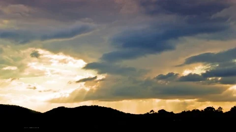 Clouds moving over mountains at sunset Vidéo 76103978