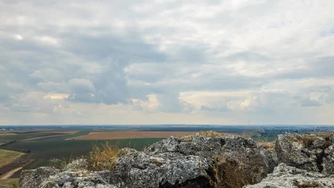Clouds moving over rock formation and field Stock Footage 117070158