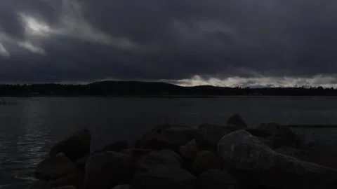 Clouds moving over rocks by the beach Stock Footage 250476883