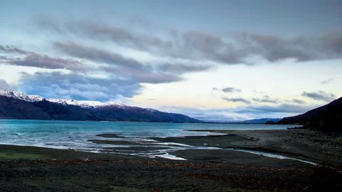 Clouds moving over snow covered mountains and Wanaka lake Stock Footage 76105947