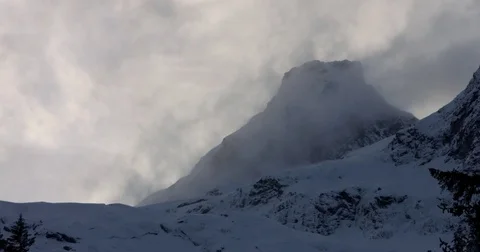 Clouds moving over the snow covered mountains during winter Stock Footage 77765924