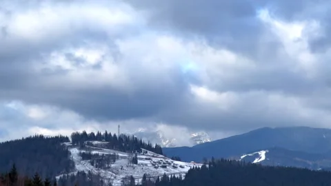 Clouds moving over snowy mountain village Stock Footage 312802958