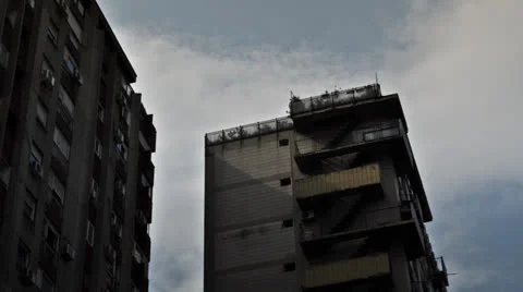 Clouds moving over socialist looking buildings during the day in the city center Stock Footage 22482315